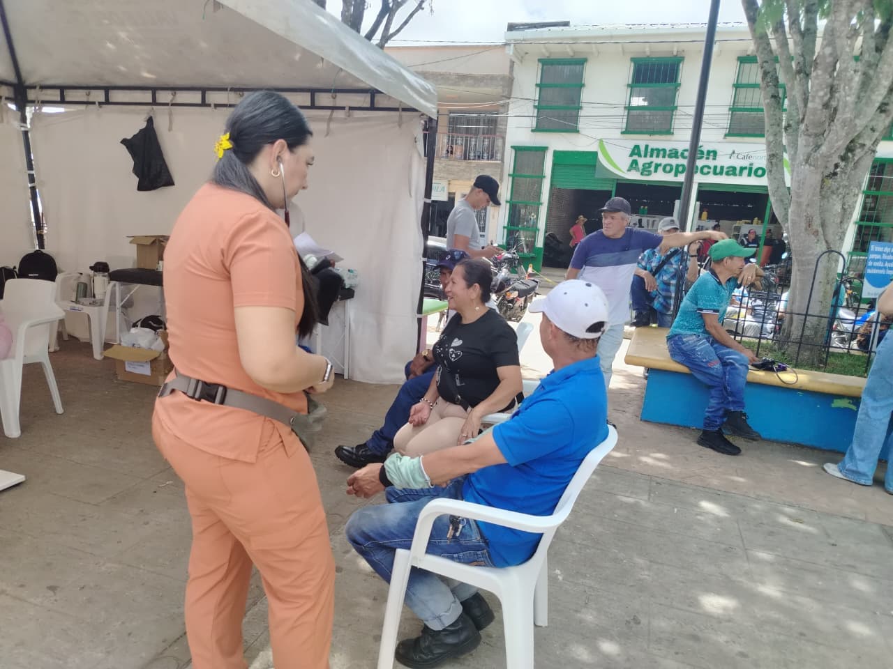 Profesional de la fundación conversando con adultos mayores en la plaza