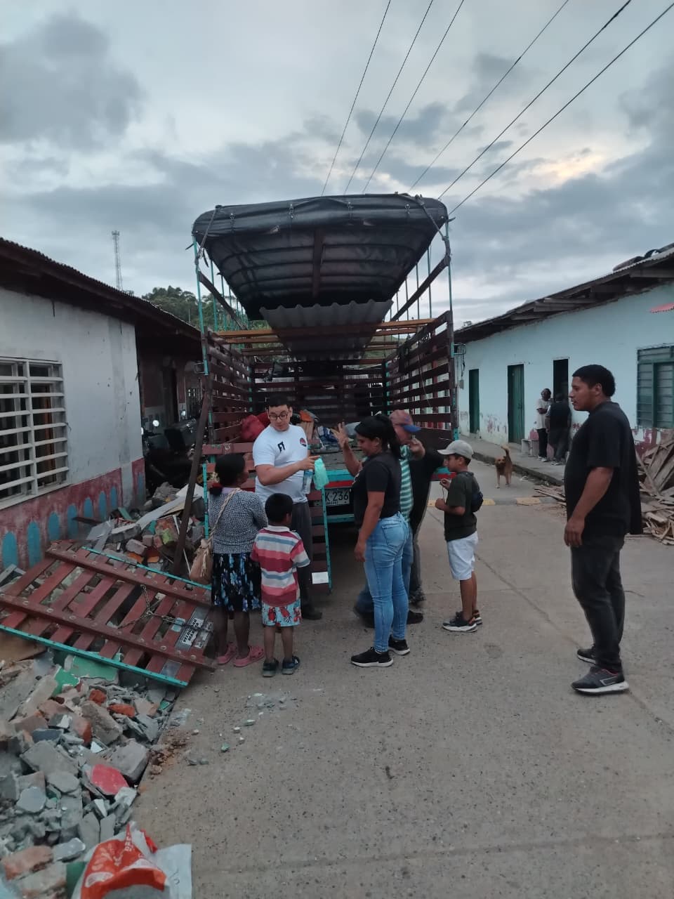 Entrega de ayuda a familias de la comunidad junto a un camión de carga