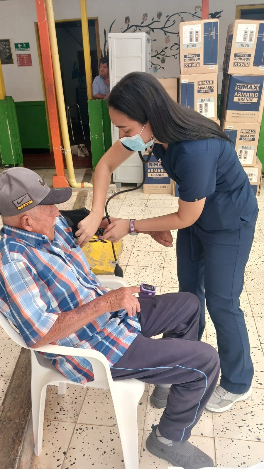Profesional de la salud tomando la presión arterial a un adulto mayor